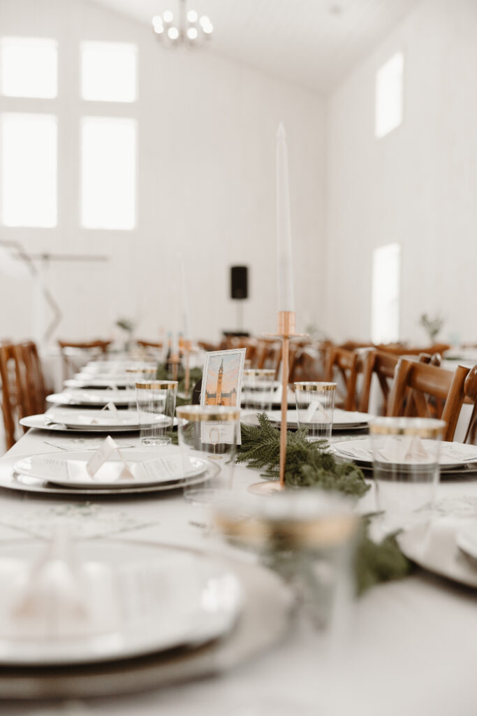 Elegant winter wedding table setting with candles and greenery at Grand Ivory