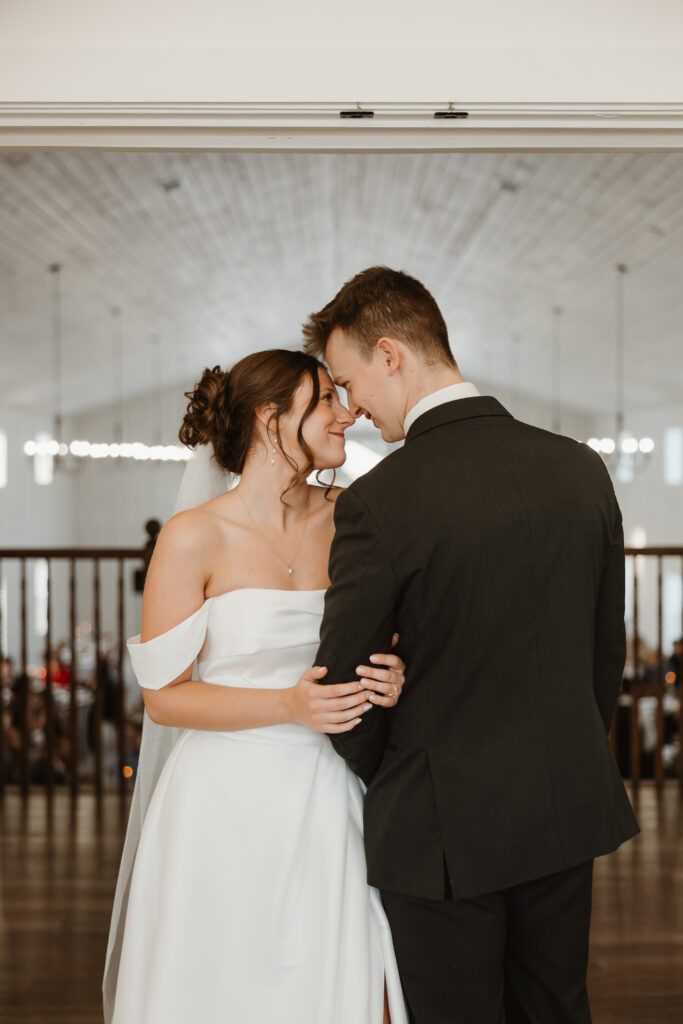 Bride and groom touching noses during couple portraits in the Grand Ivory bridal suite