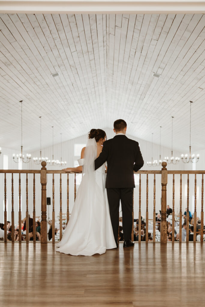 Bride and groom overlooking the reception hall from the bridal balcony at Grand Ivory