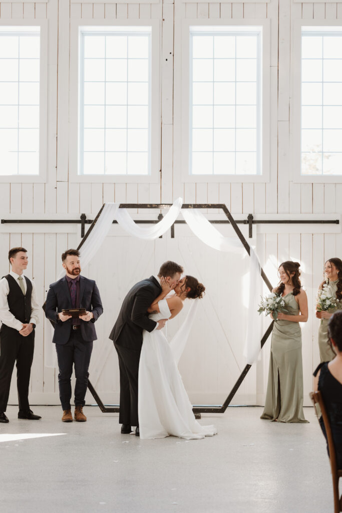 Bride and groom sharing their first kiss as a married couple at Grand Ivory wedding Moncton New Brunswick