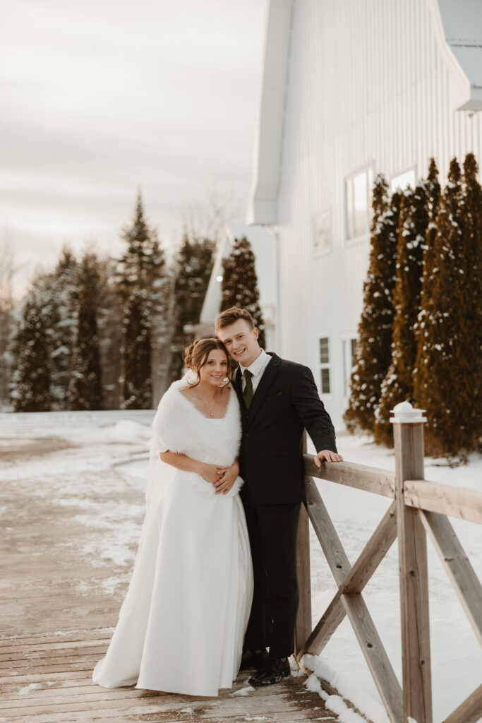 Bride and groom standing in the snow in front of the Grand Ivory in Moncton New Brunswick