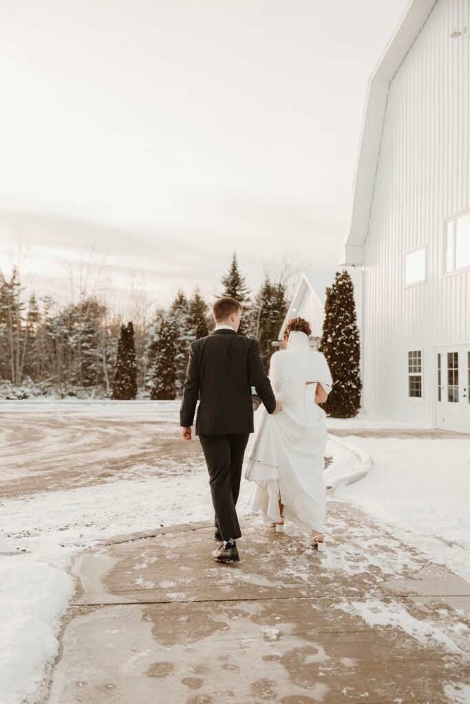 Bride and groom walking towards the Grand Ivory during their winter wedding