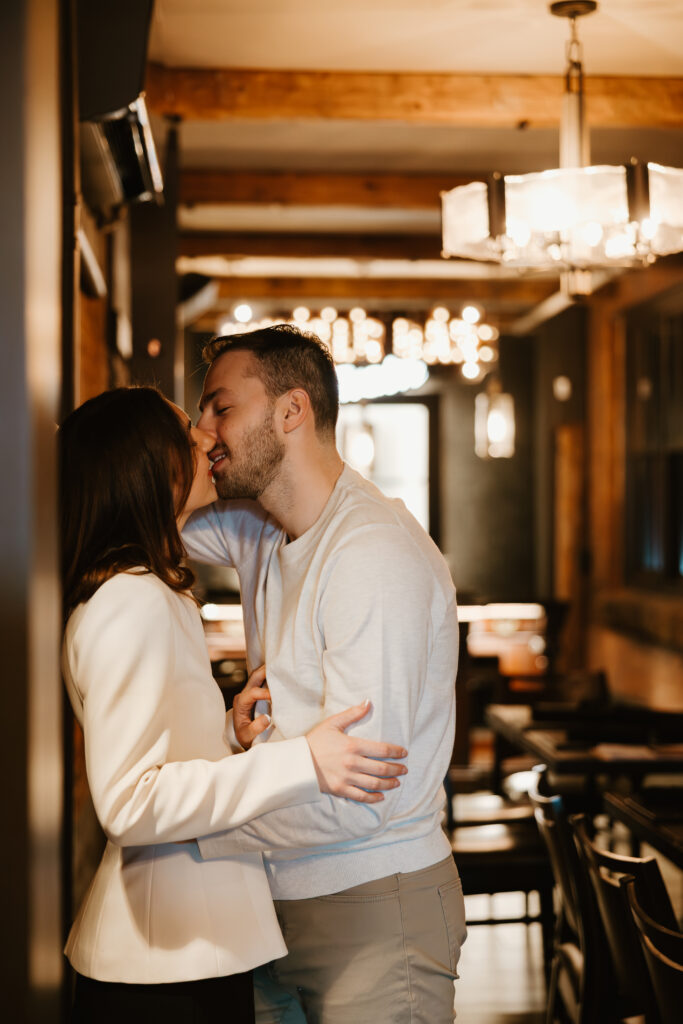 couple against wall kissing in bar