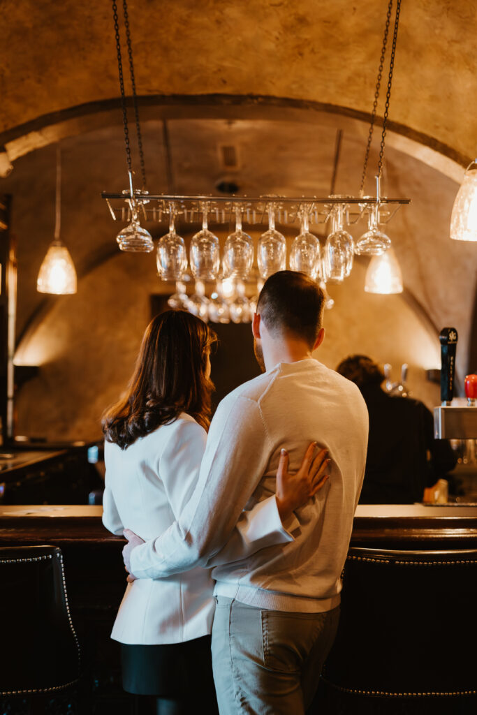 looking at back of couple arm in arm at the bar