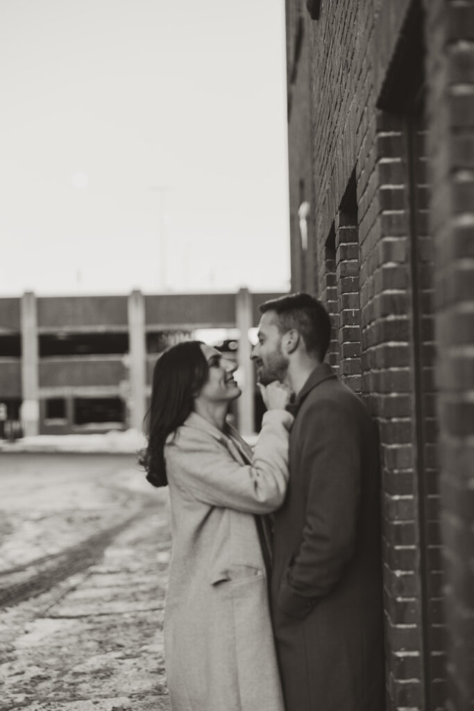 couple against wall downtown engagement pictures