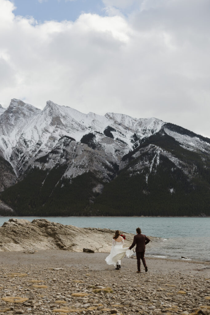 Lake Minnewanka elopement walking on beach