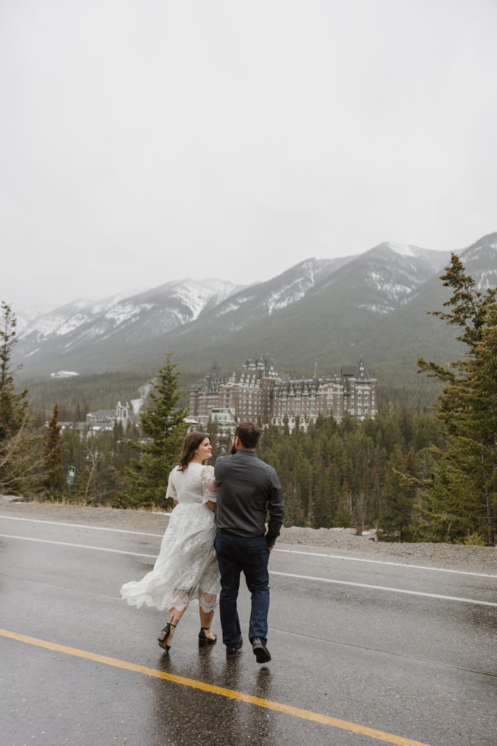 Couple running towards Chateau Fairmont Banff Alberta