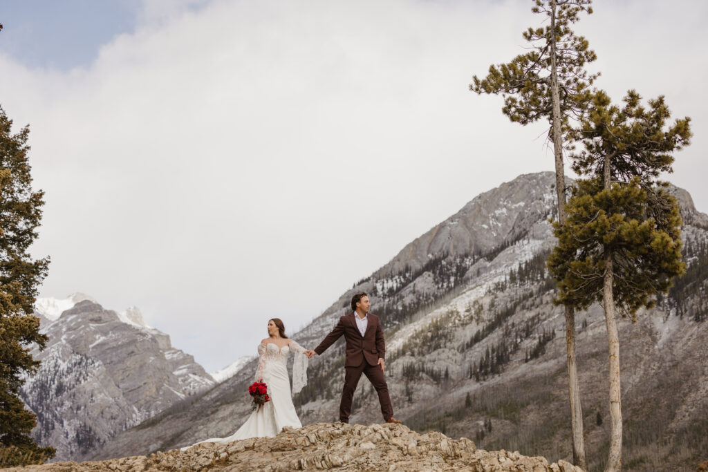 Lake Minnewanka elopement holding hands on mountain