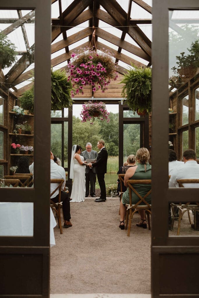 Intimate wedding ceremony inside glass greenhouse pavilion Moncton NB summer