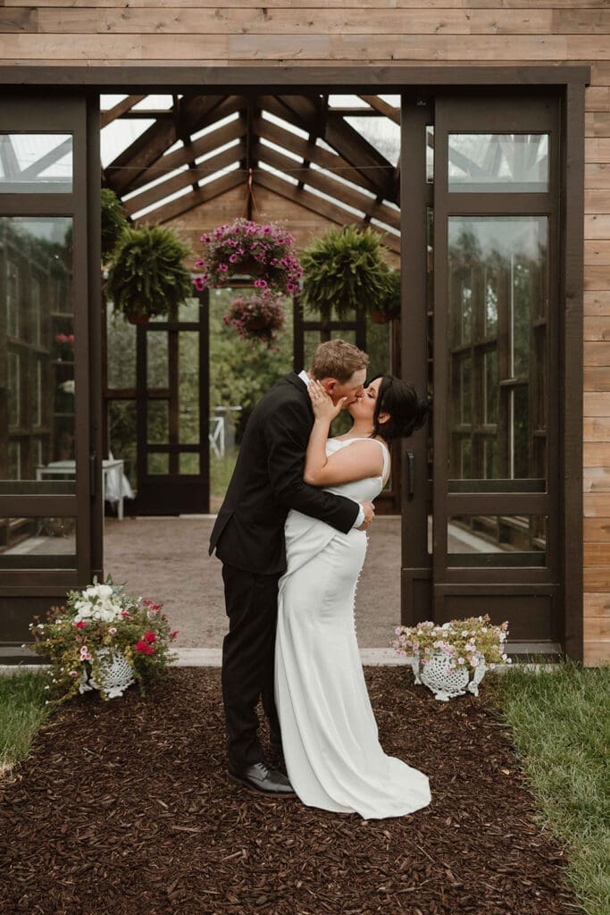 Bride and groom first kiss at The Pavilion Moncton greenhouse weddin