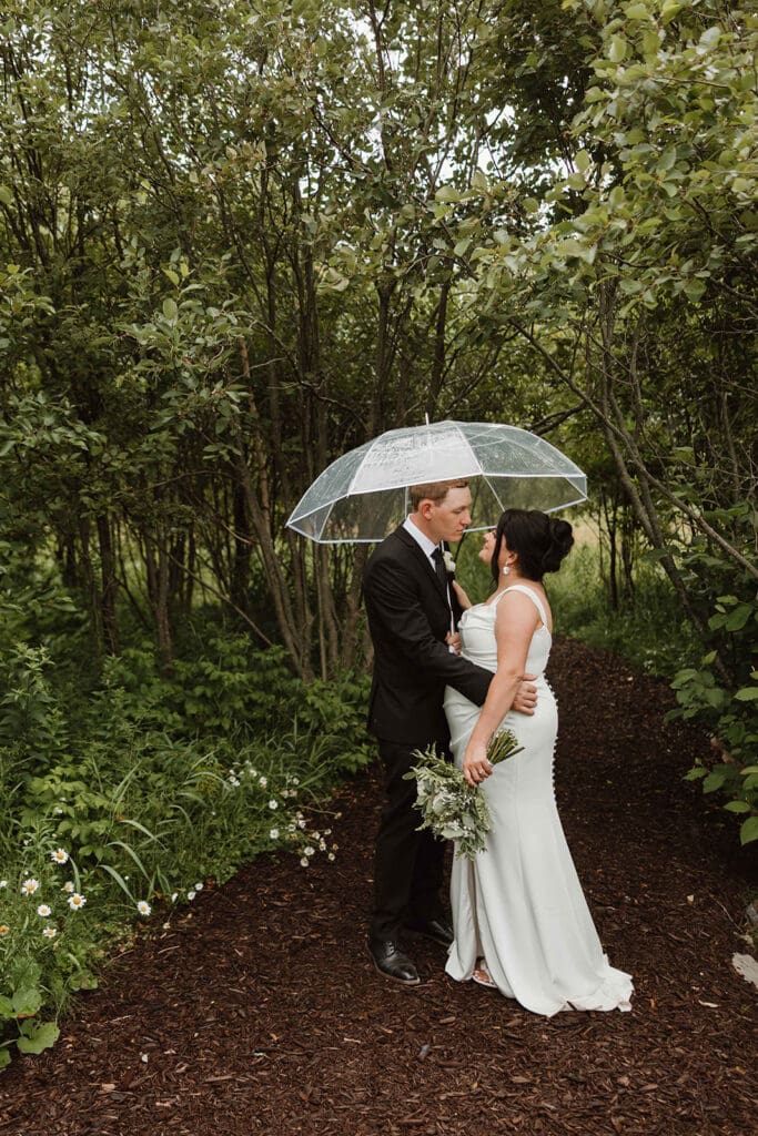 Couple in greenery pathway at The Pavilion Moncton summer wedding