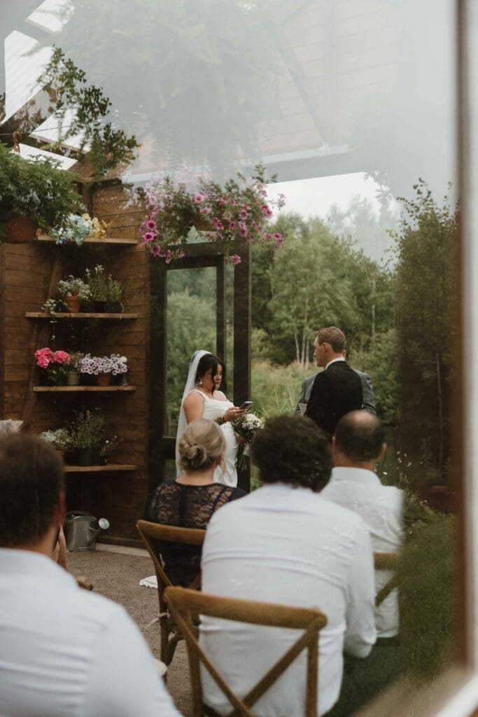 Intimate wedding ceremony inside glass greenhouse pavilion Moncton NB summer